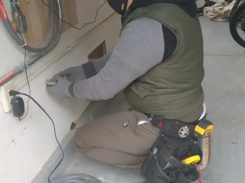 Electrician performing outlet wiring in a Los Ranchos de Albuquerque garage
